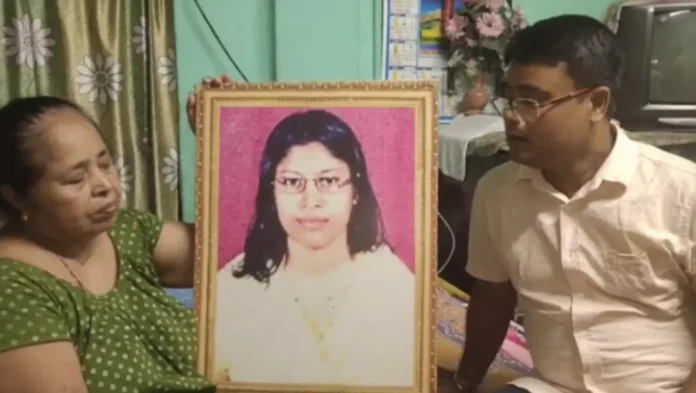 Family members of late teacher Rita Sarkar hold her photograph while renewing their demand for a fair investigation into her death case in Siliguri. Tuesday, 26 May 2026.